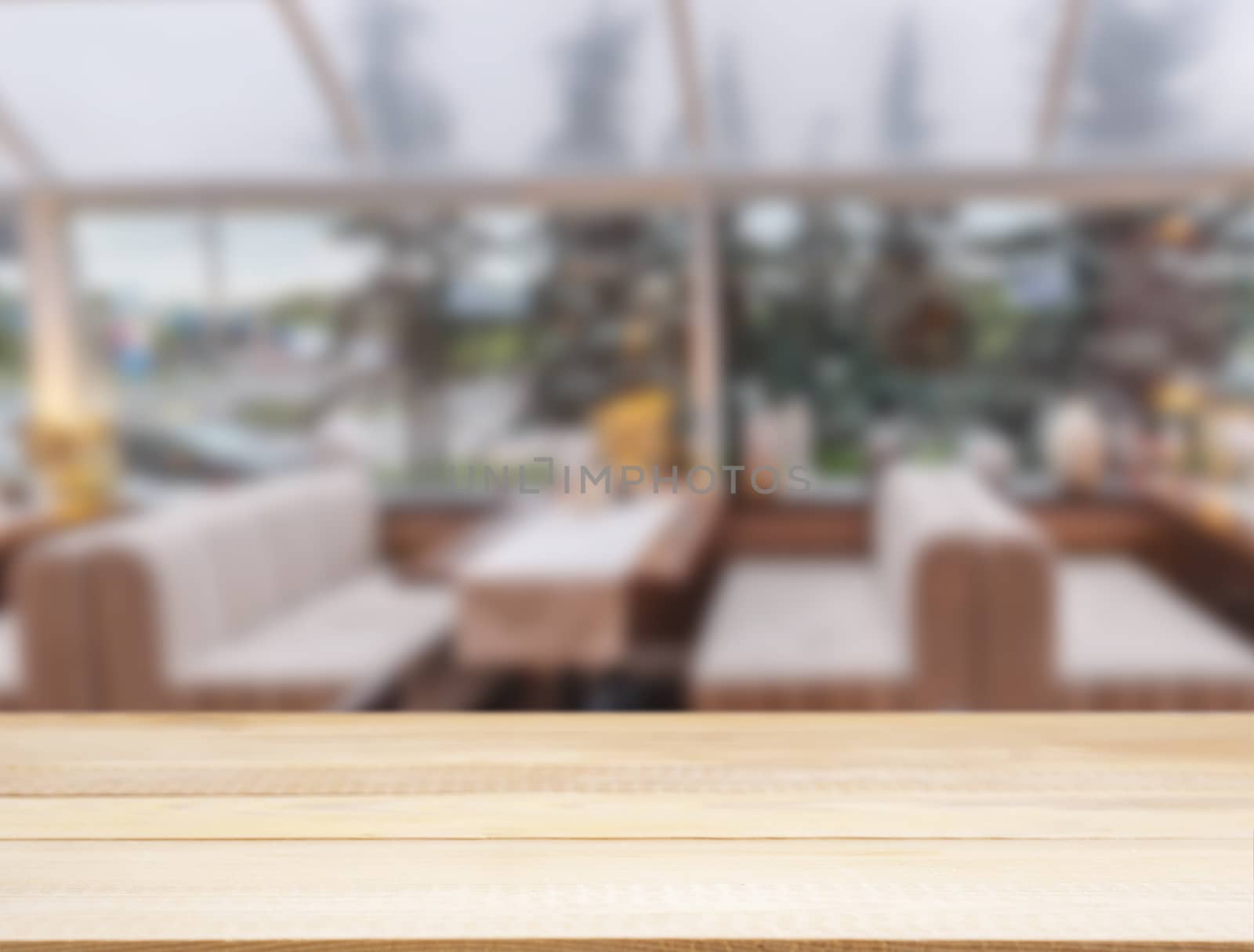 Wooden board empty table in front of blurred cafe by fascinadora