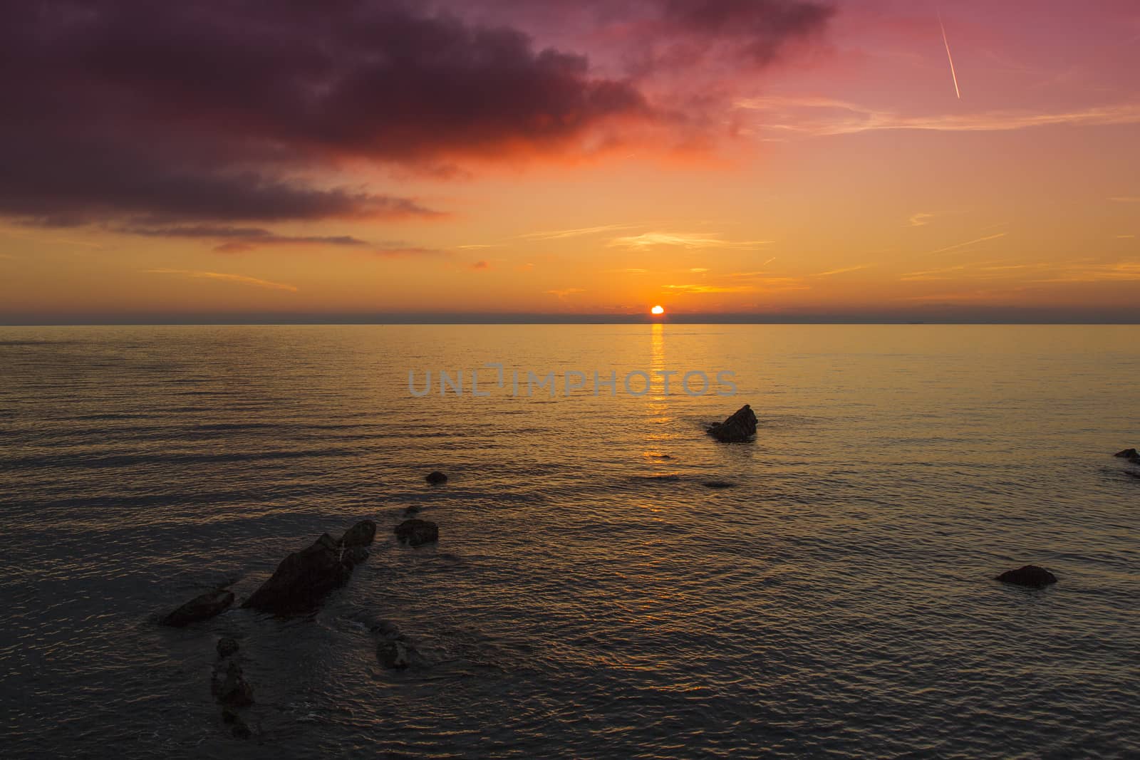 Sea panoramic view of the sun setting with purple sky