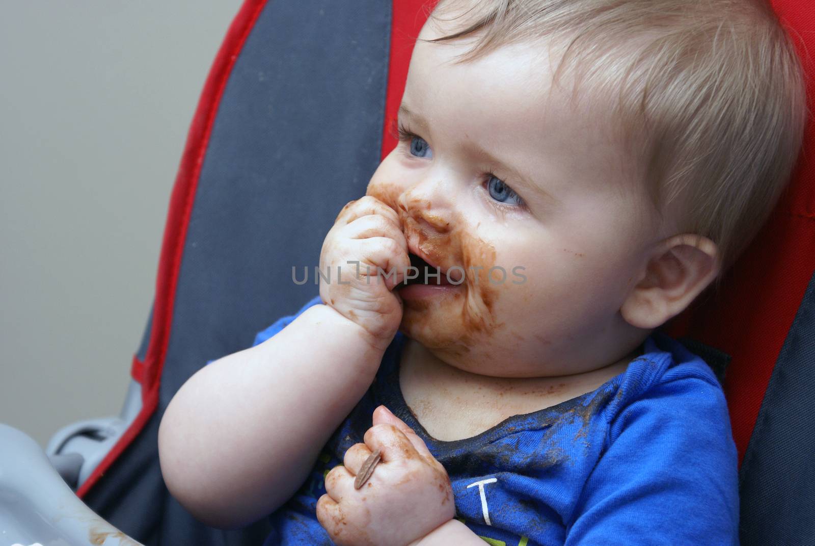 A baby boy experiences his first piece of chocolate.