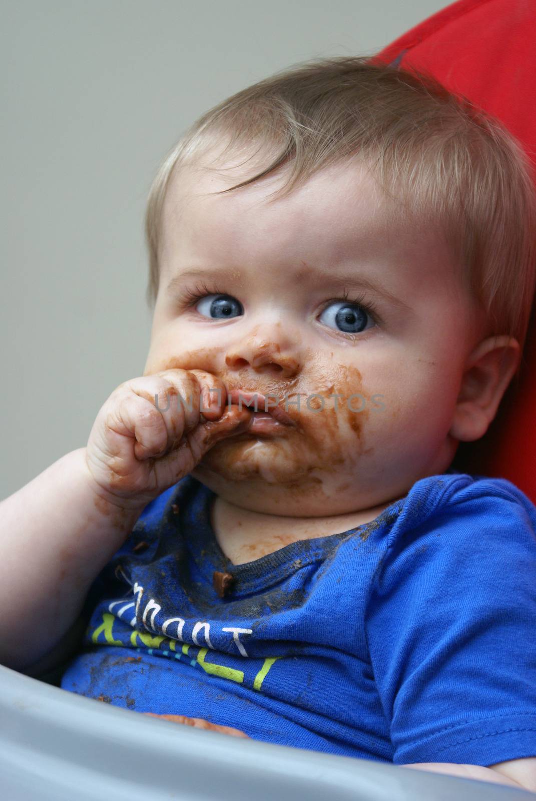 A baby boy experiences his first piece of chocolate.