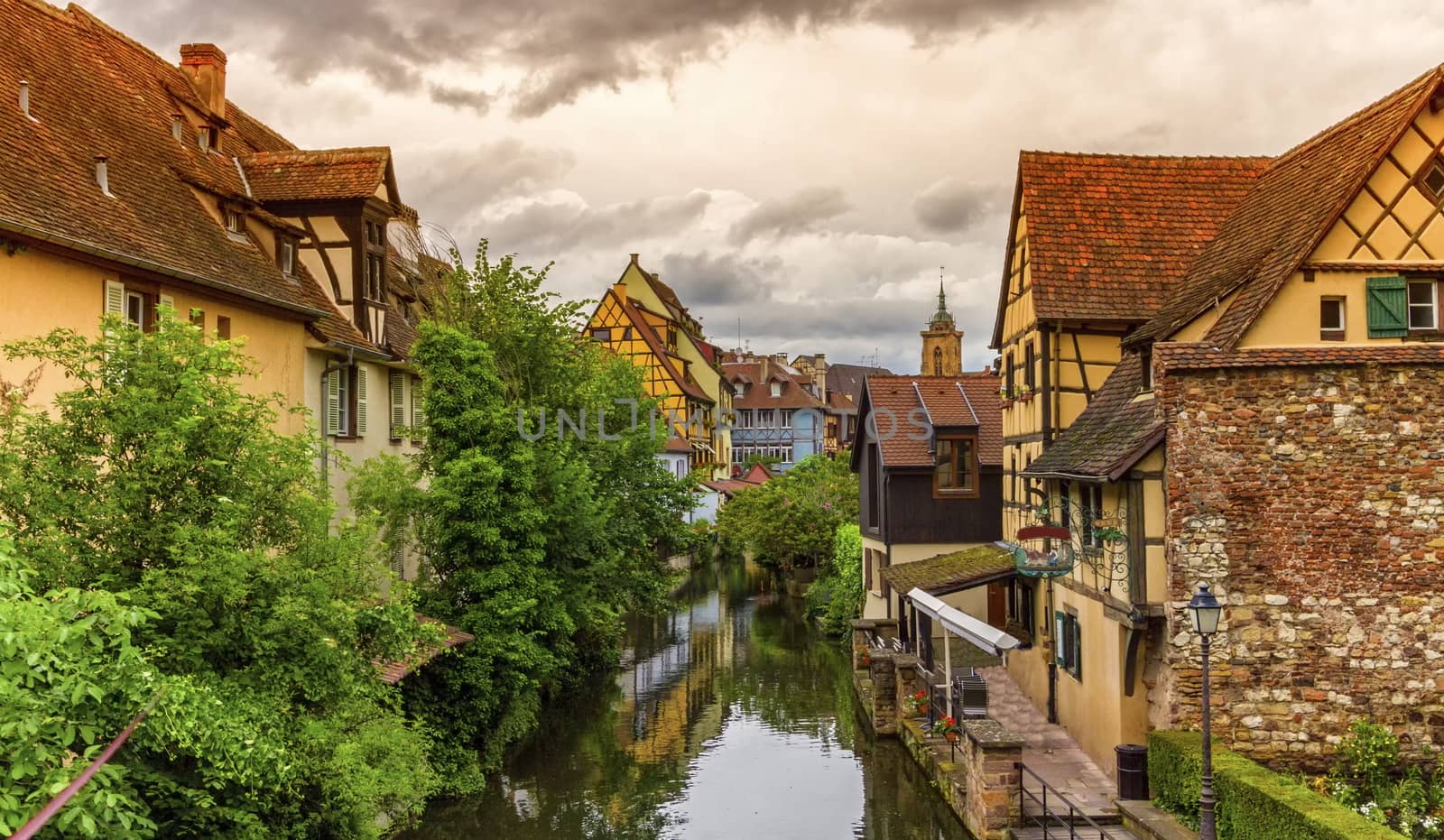 Famous traditional colorful timbered houses in Little Venice, petite Venise and tower of the church, Colmar, Alsace, France