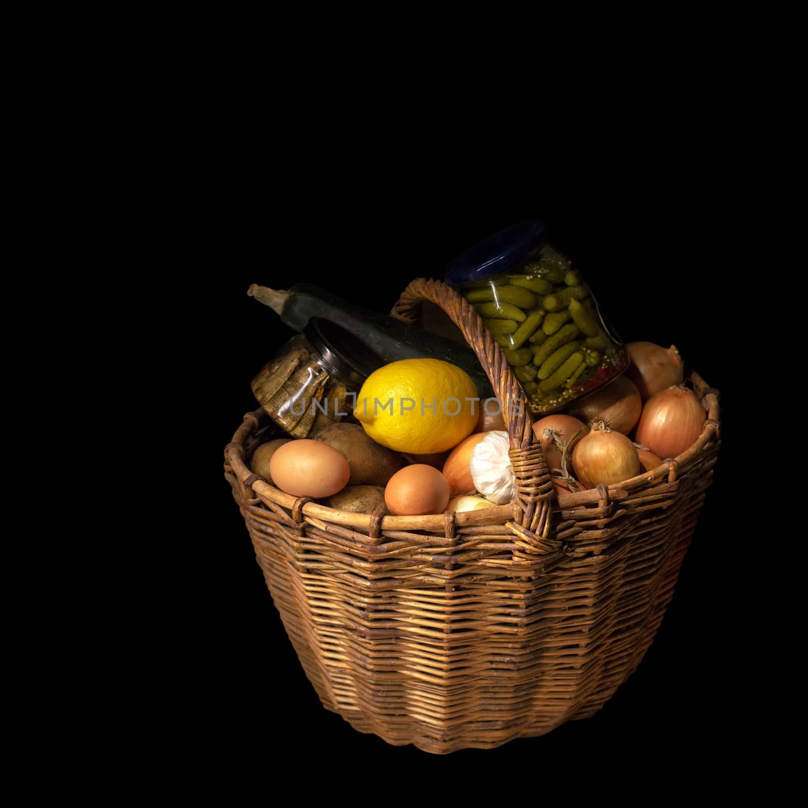 Old, rustic basket, on a black background filled with products