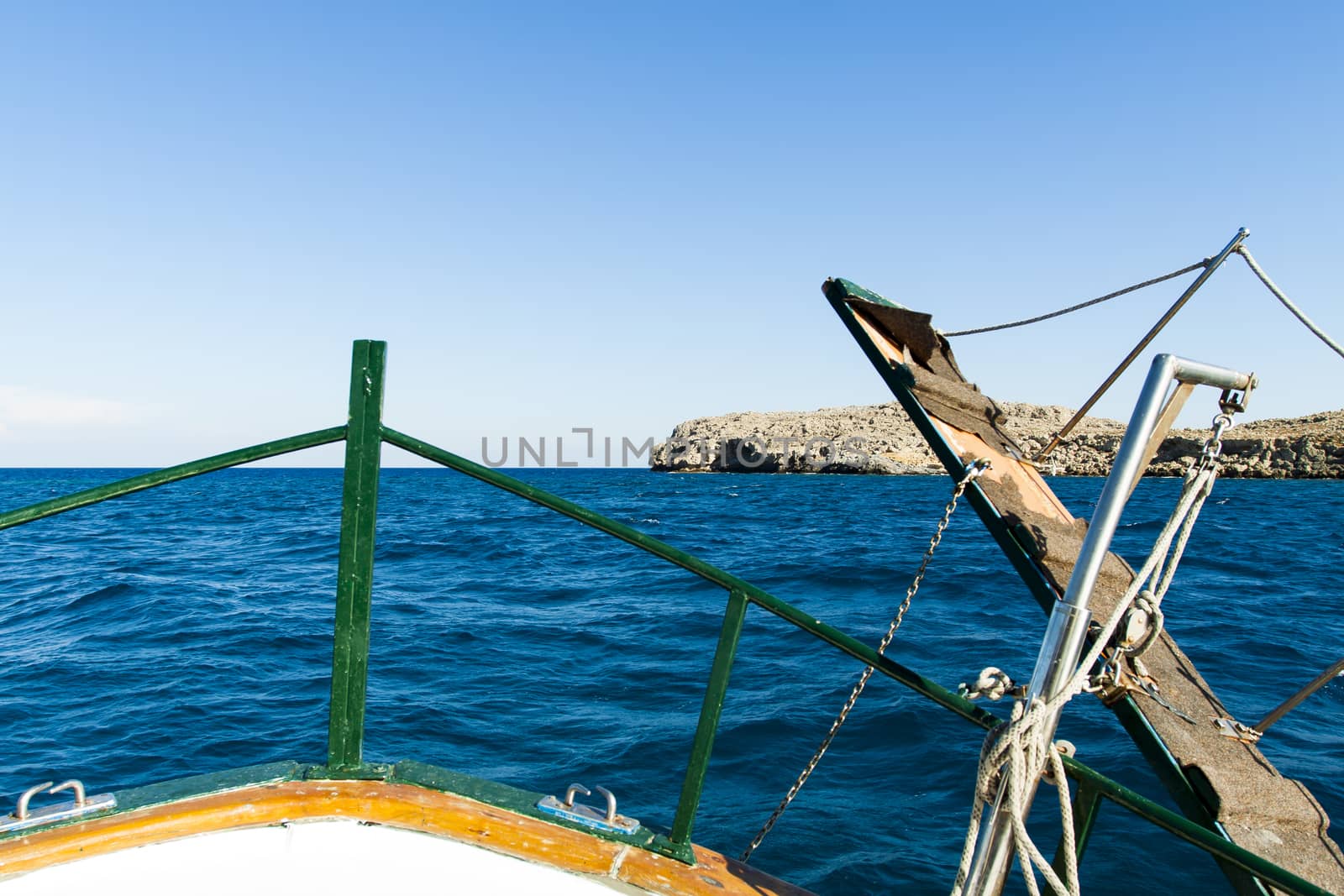 View of the coast of the island of Rhodes by the bow of a boat