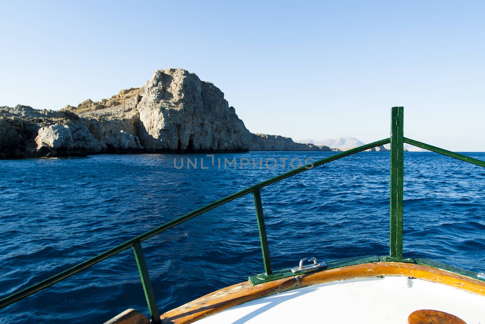 View of the coast of the island of Rhodes by the bow of a boat