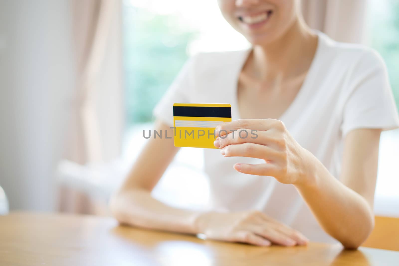 Happy blond woman showing blank credit card. Focus on card. by ekachailo