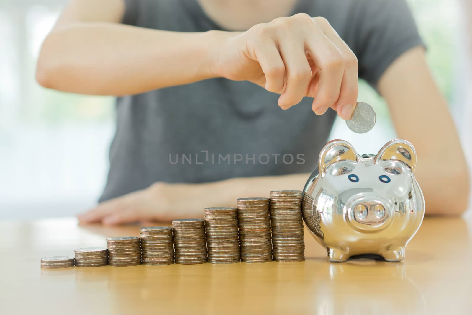 saving money-young woman putting a coin into a money-box-close up