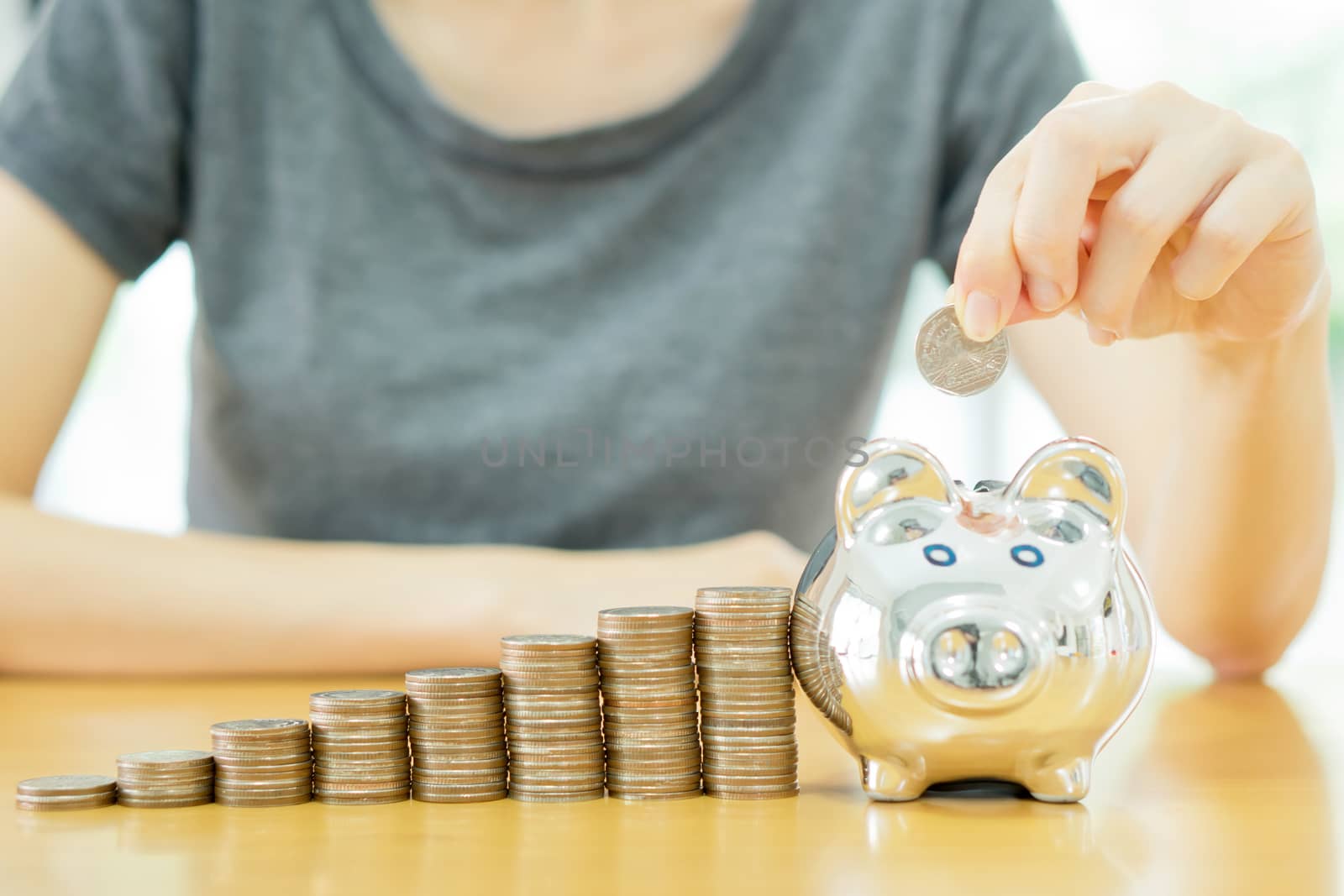 saving money-young woman putting a coin into a money-box-close up