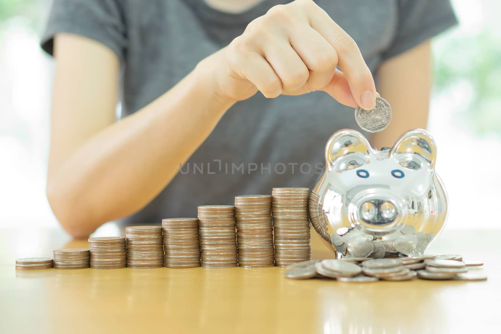 saving money-young woman putting a coin into a money-box-close up