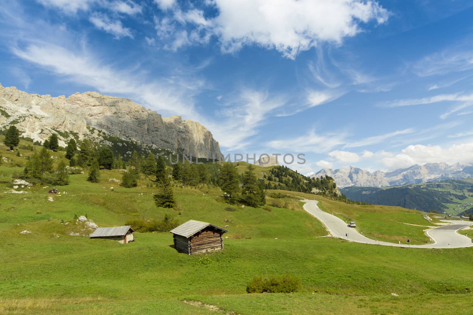 View of a high mountain refuge in a green valley, blue sky and the Dolomite Mountains