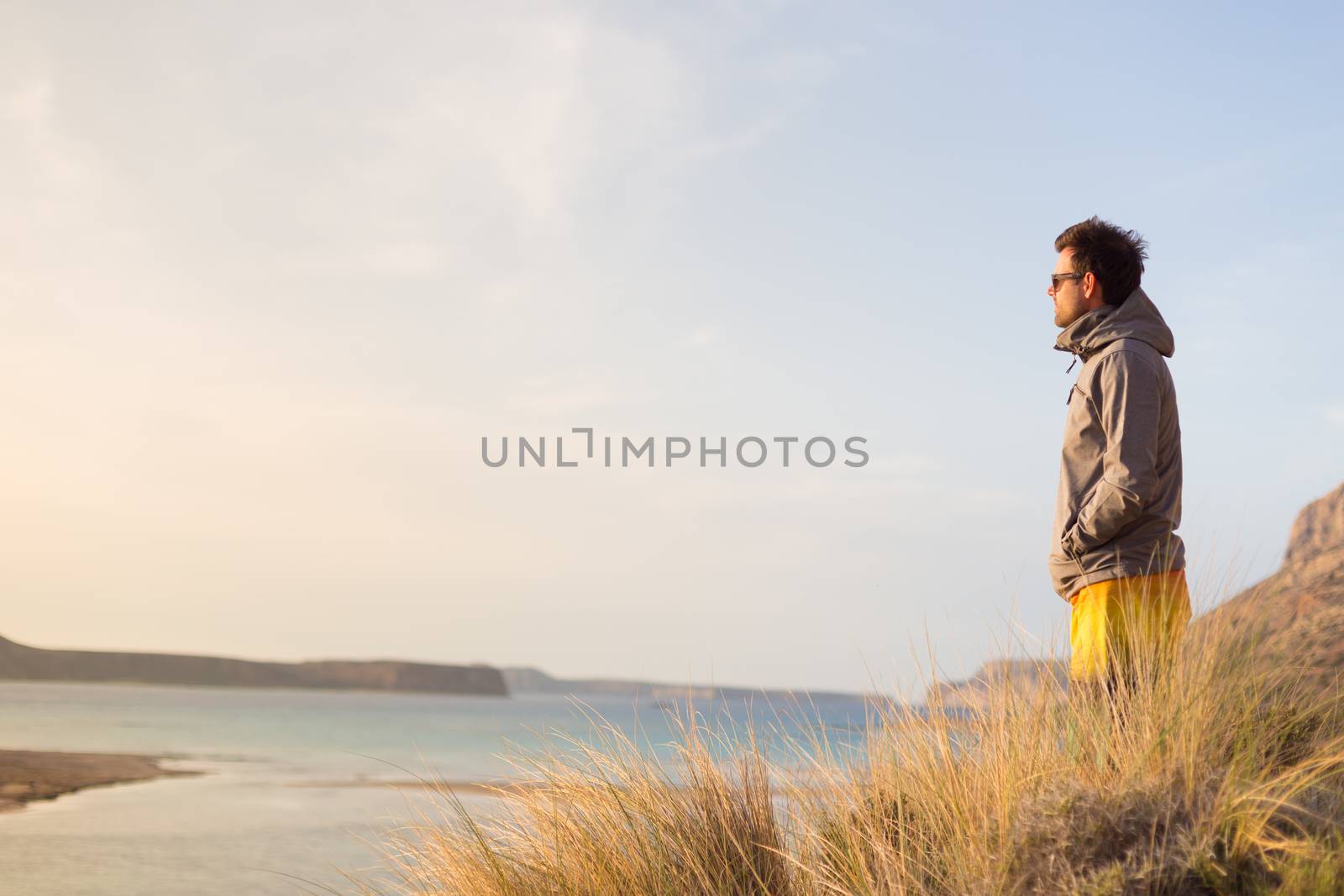 Sporty active man looking in distance, enjoying beauty of nature, freedom and life at beautiful landscape. Active lifestyle outdoors.