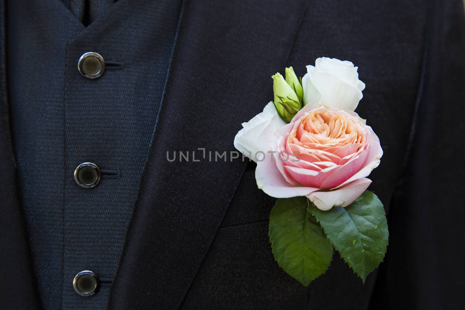 Close up view of a particular floral accessory on a groom's suit