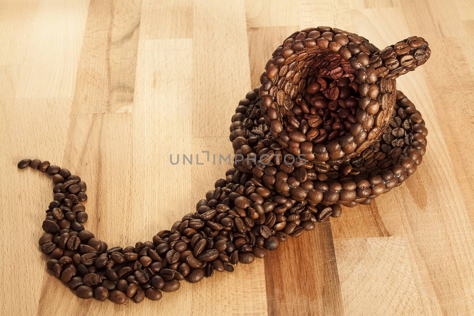 Close up view of a cup covered with coffee beans on a wooden surface