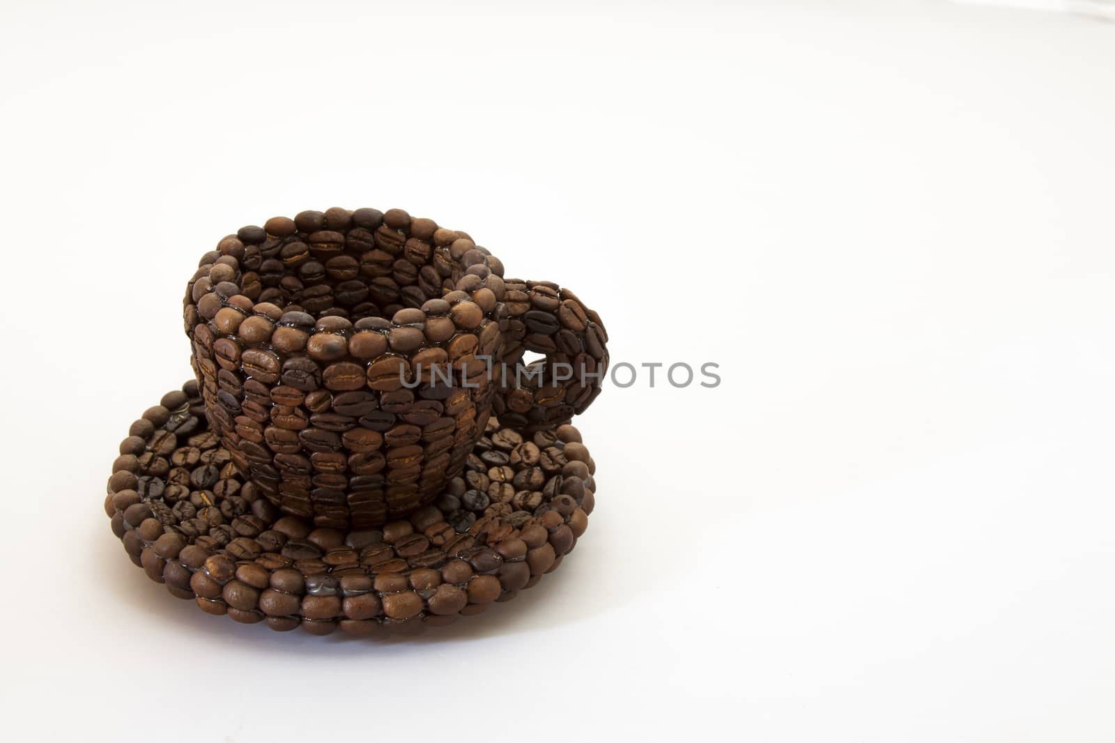 Close up view of a cup covered with coffee beans and white background