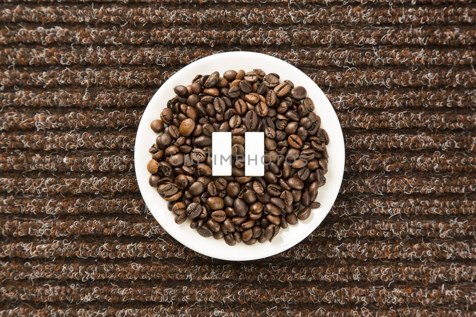 Concept of a coffee pause, coffee beans arranged in a circle with sugar cubes.