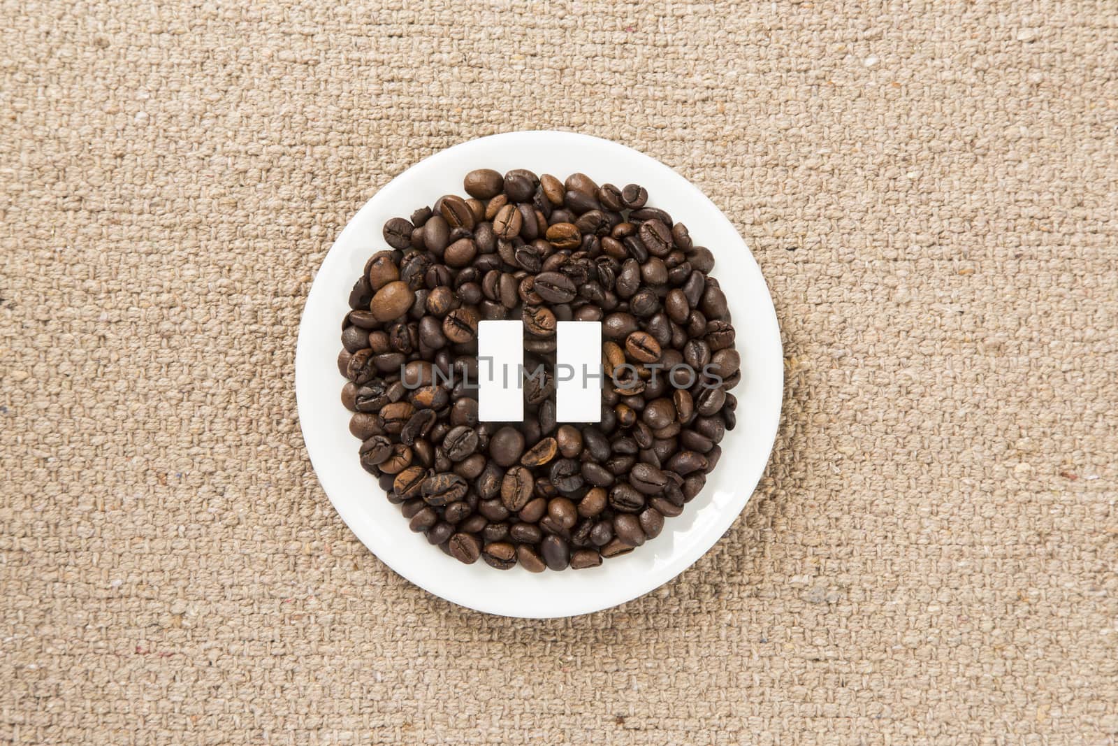 Concept of a coffee pause, coffee beans arranged in a circle with sugar cubes.