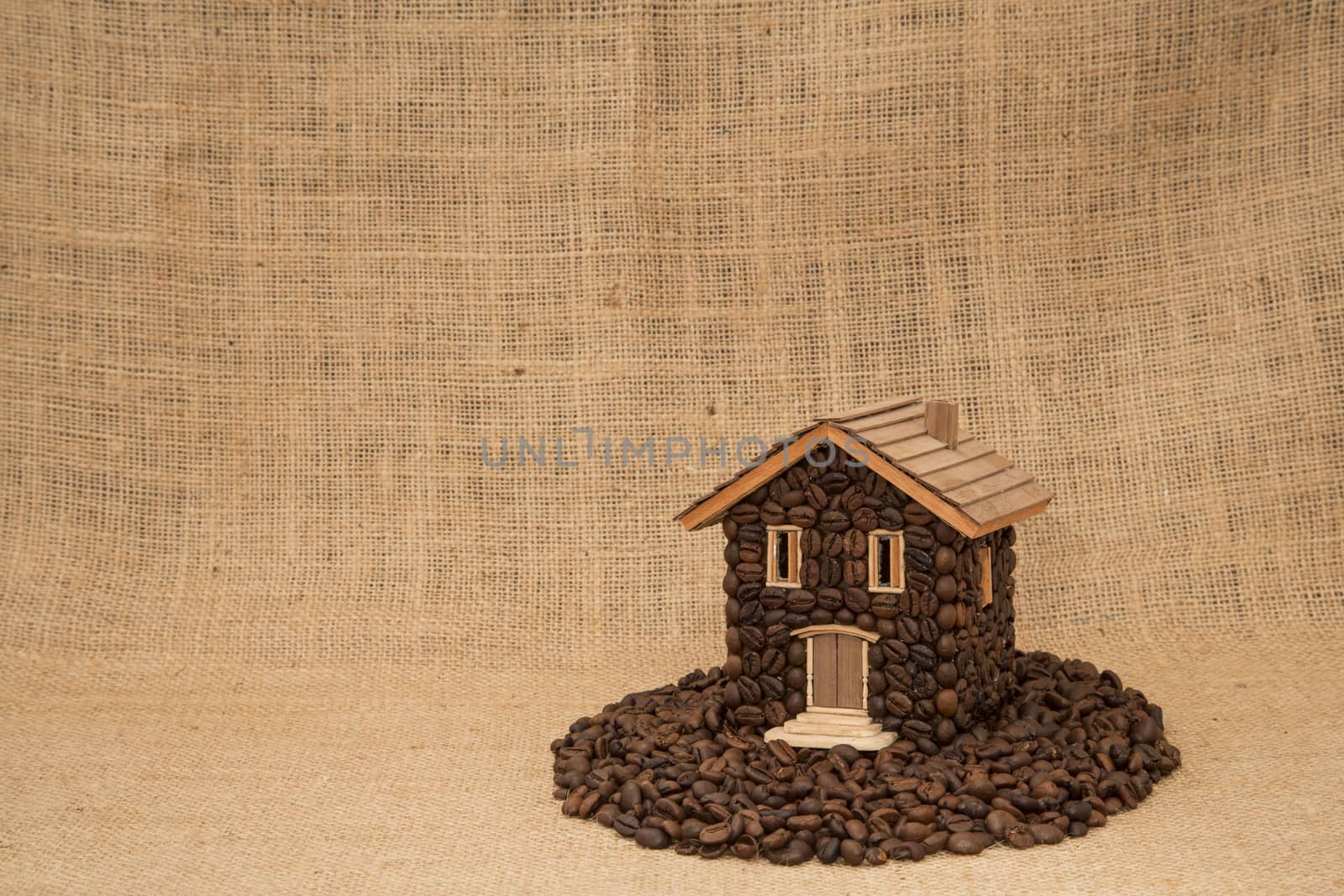 House made of coffee on juta background