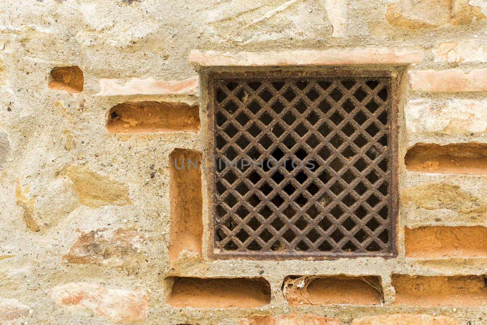 View of a detail of an ancient wall with grate