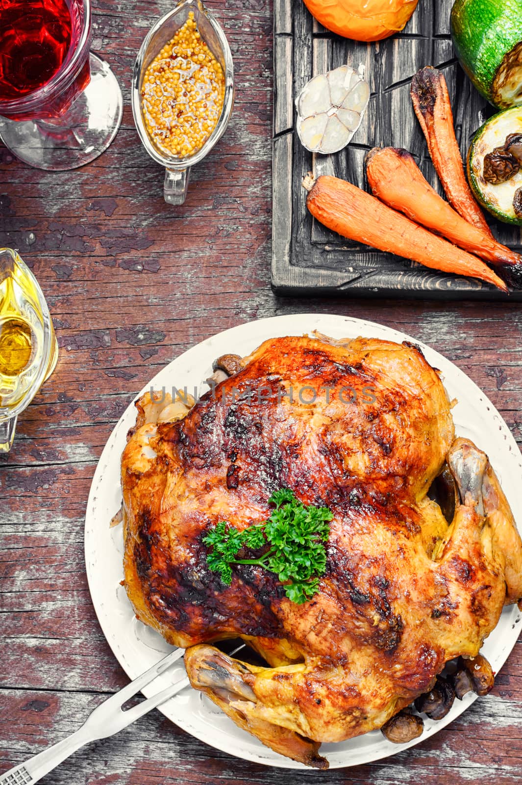 Chicken cooked in vegetables on vintage wooden surface