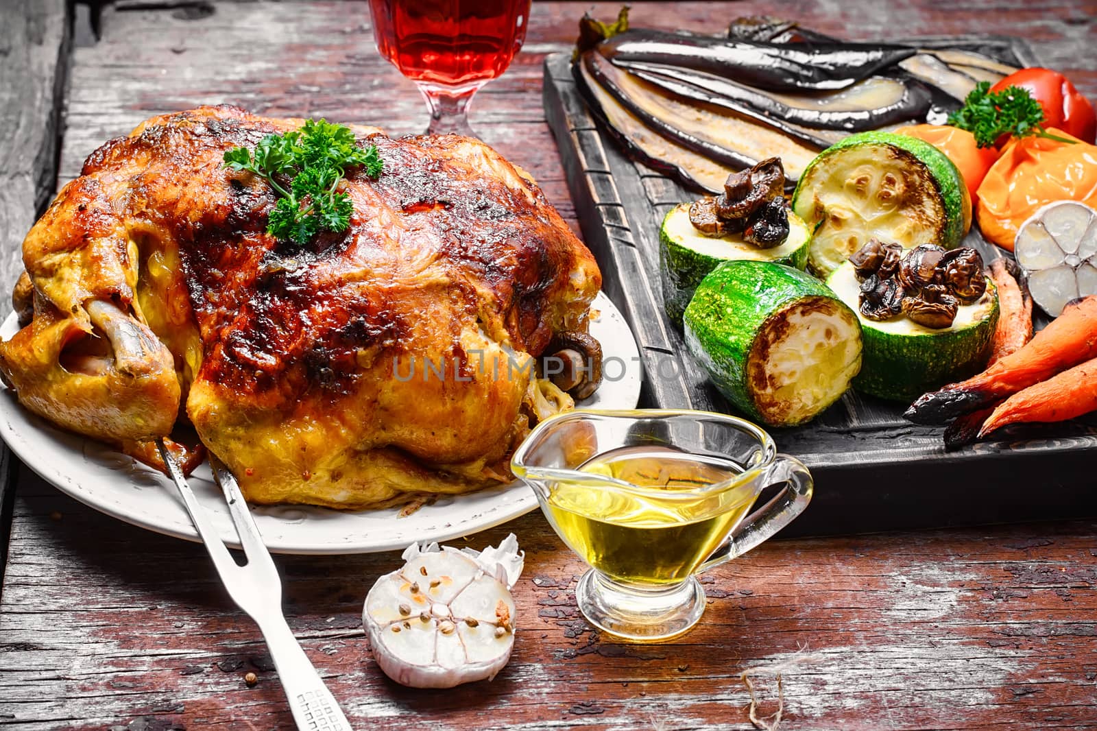 Chicken cooked in vegetables on vintage wooden surface