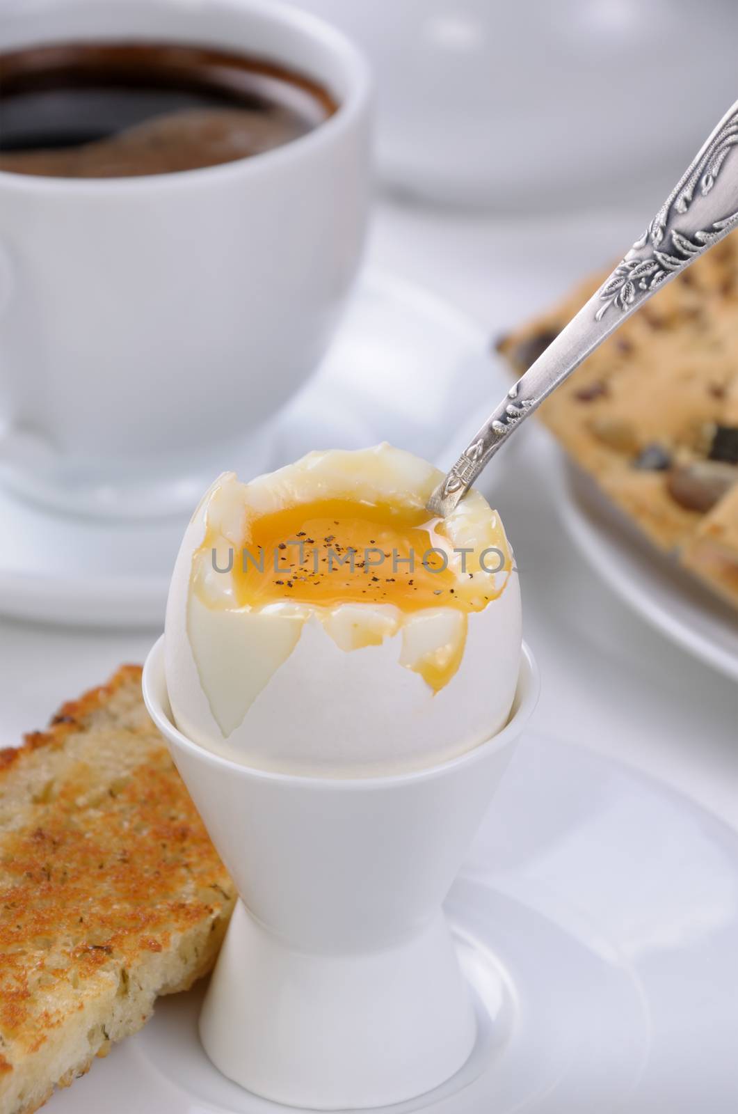 Soft-boiled egg with cup of coffee and toast for breakfast
