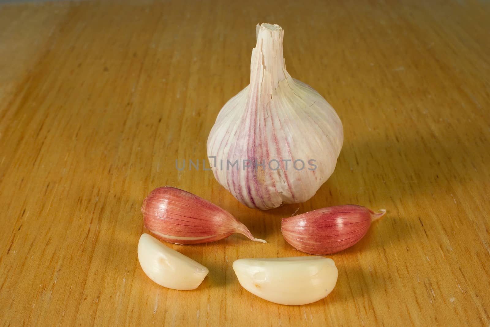 Garlic cloves on a brown breadboard