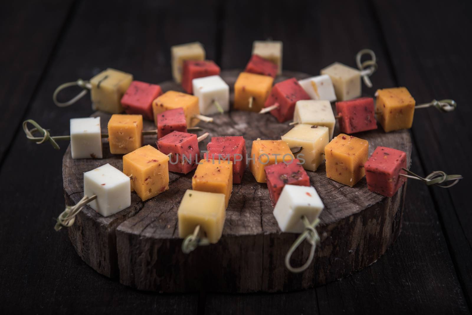 many kinds of cheeses on wooden end of a tree