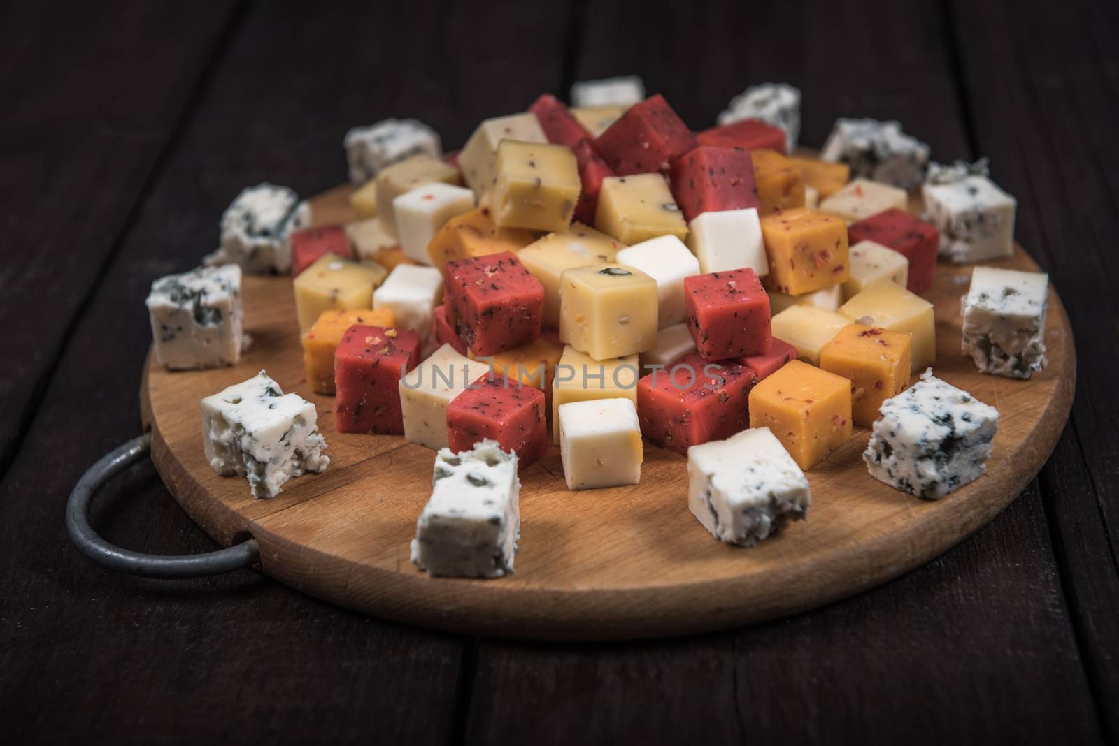 many kinds of cheeses on wooden end of a tree