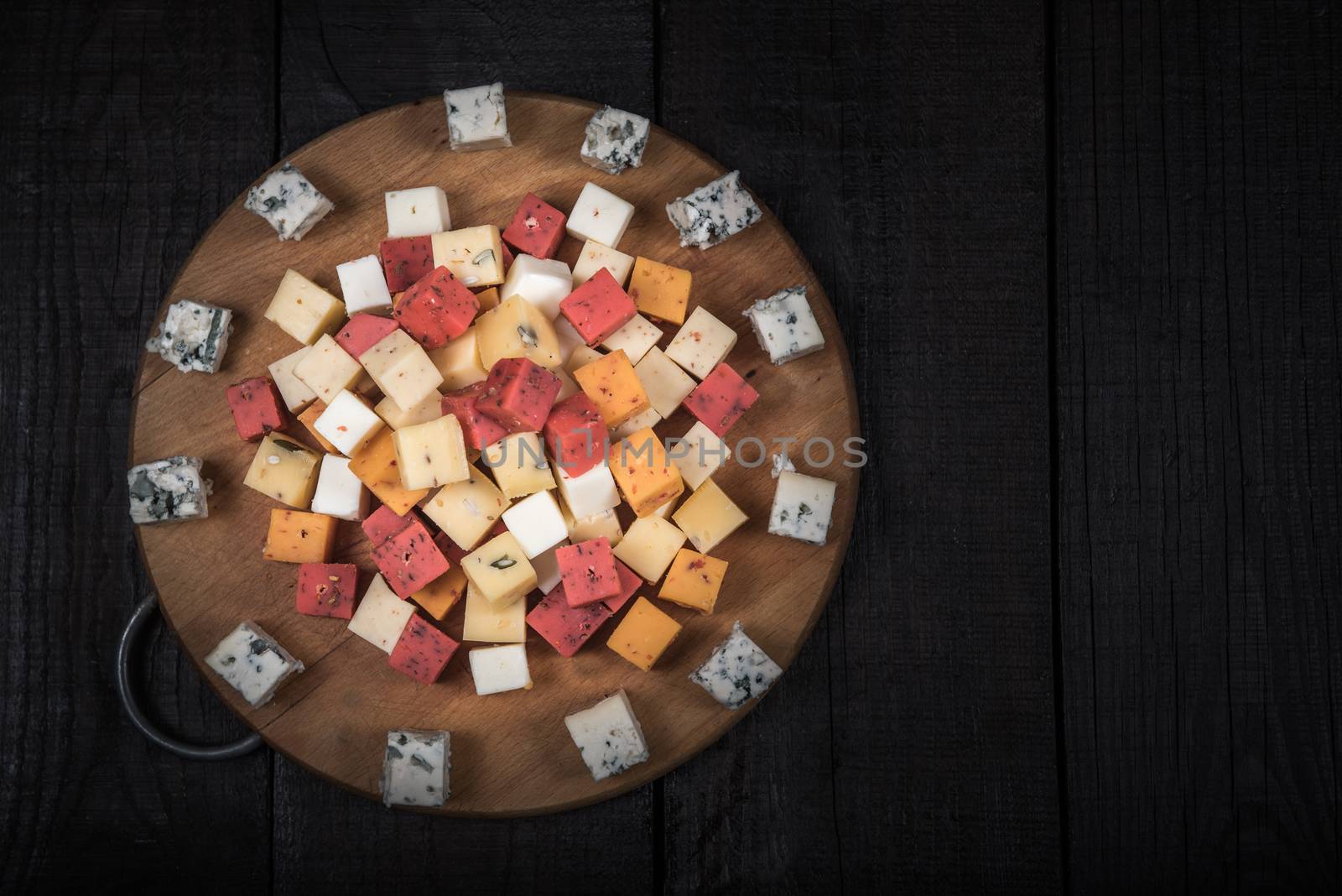 many kinds of cheeses on wooden end of a tree