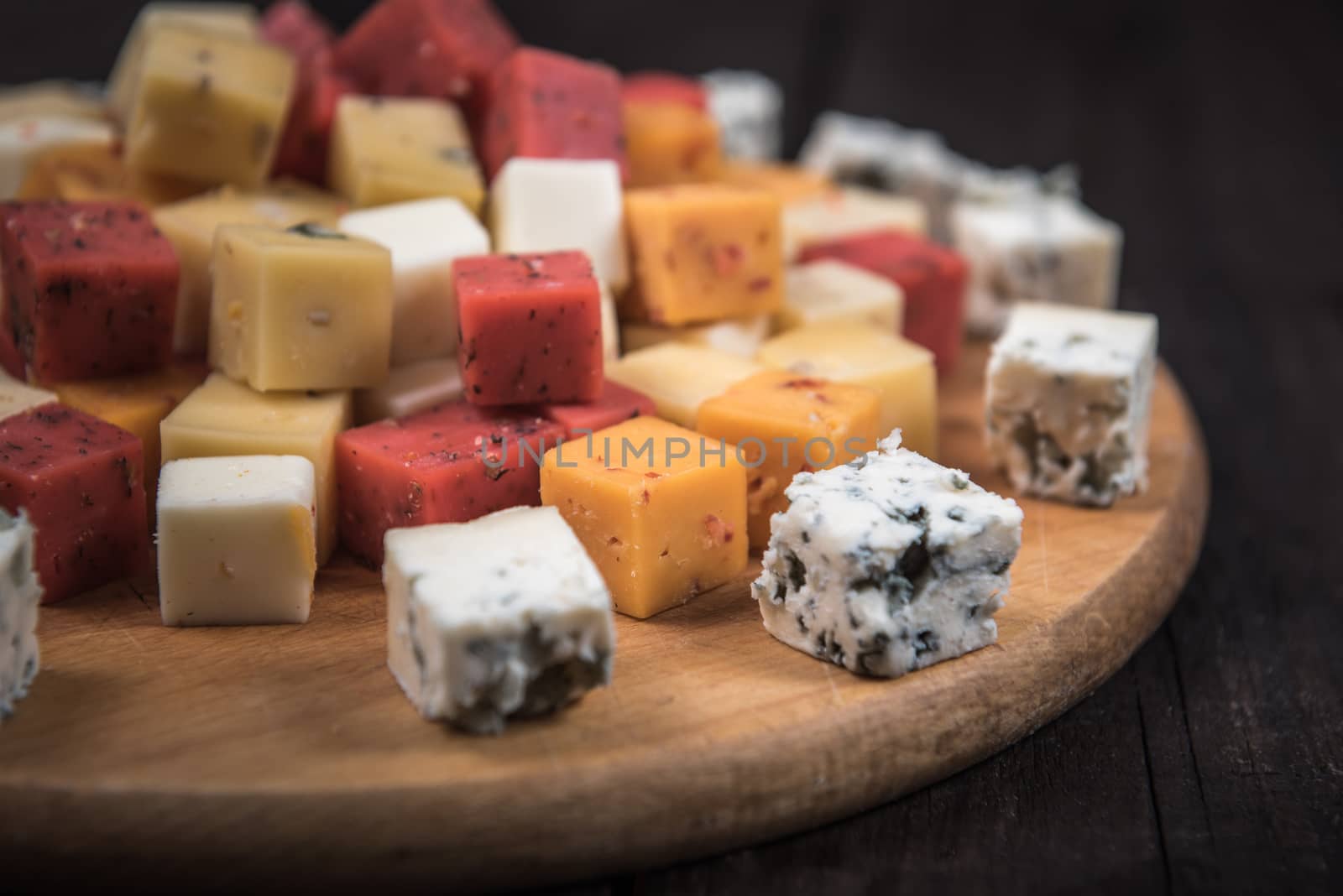 many kinds of cheeses on wooden end of a tree