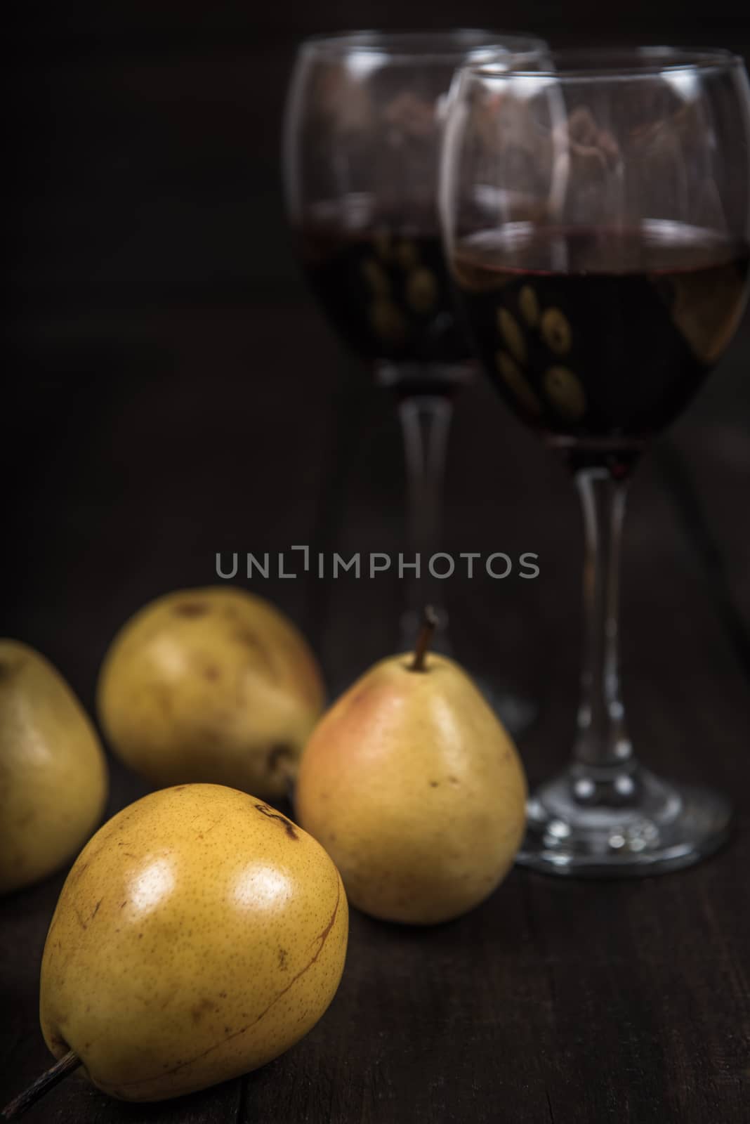 yellow pear with red wine on wooden table