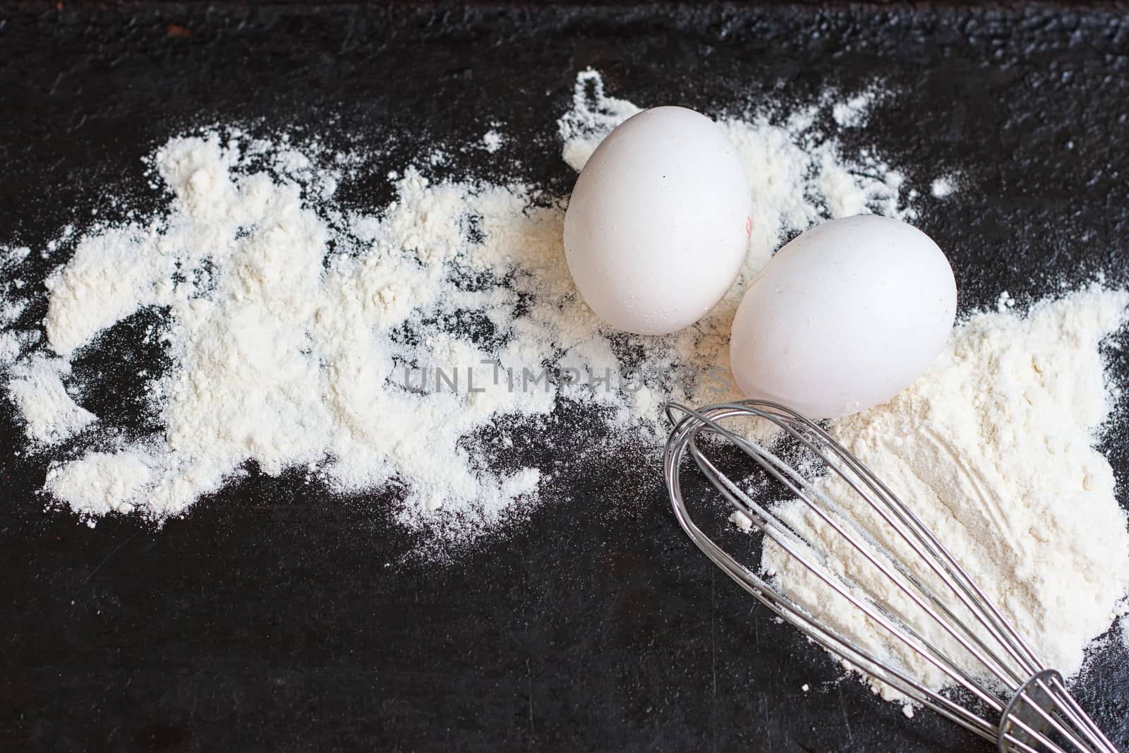 Ingredients for a cake on a black natural stone
