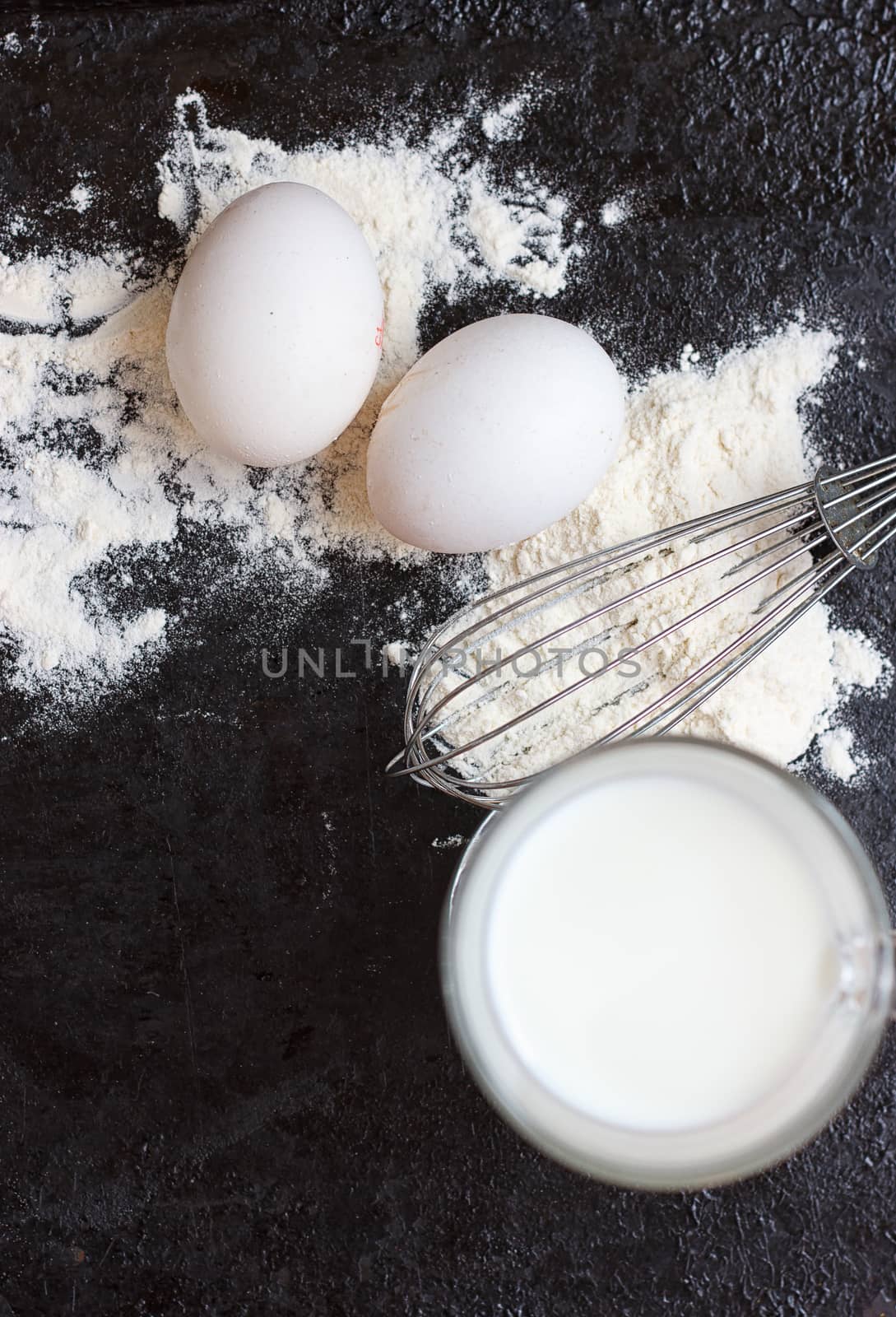 Ingredients for a cake on a black natural stone