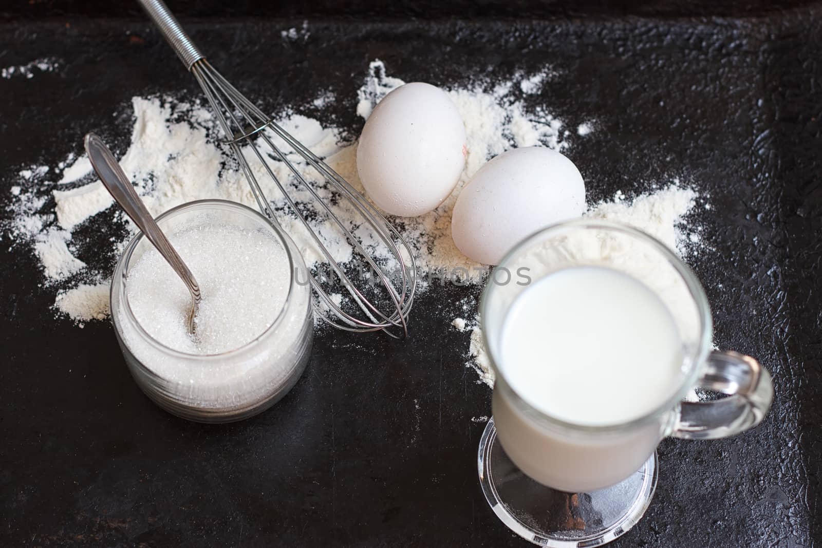 Ingredients for a cake on a black natural stone