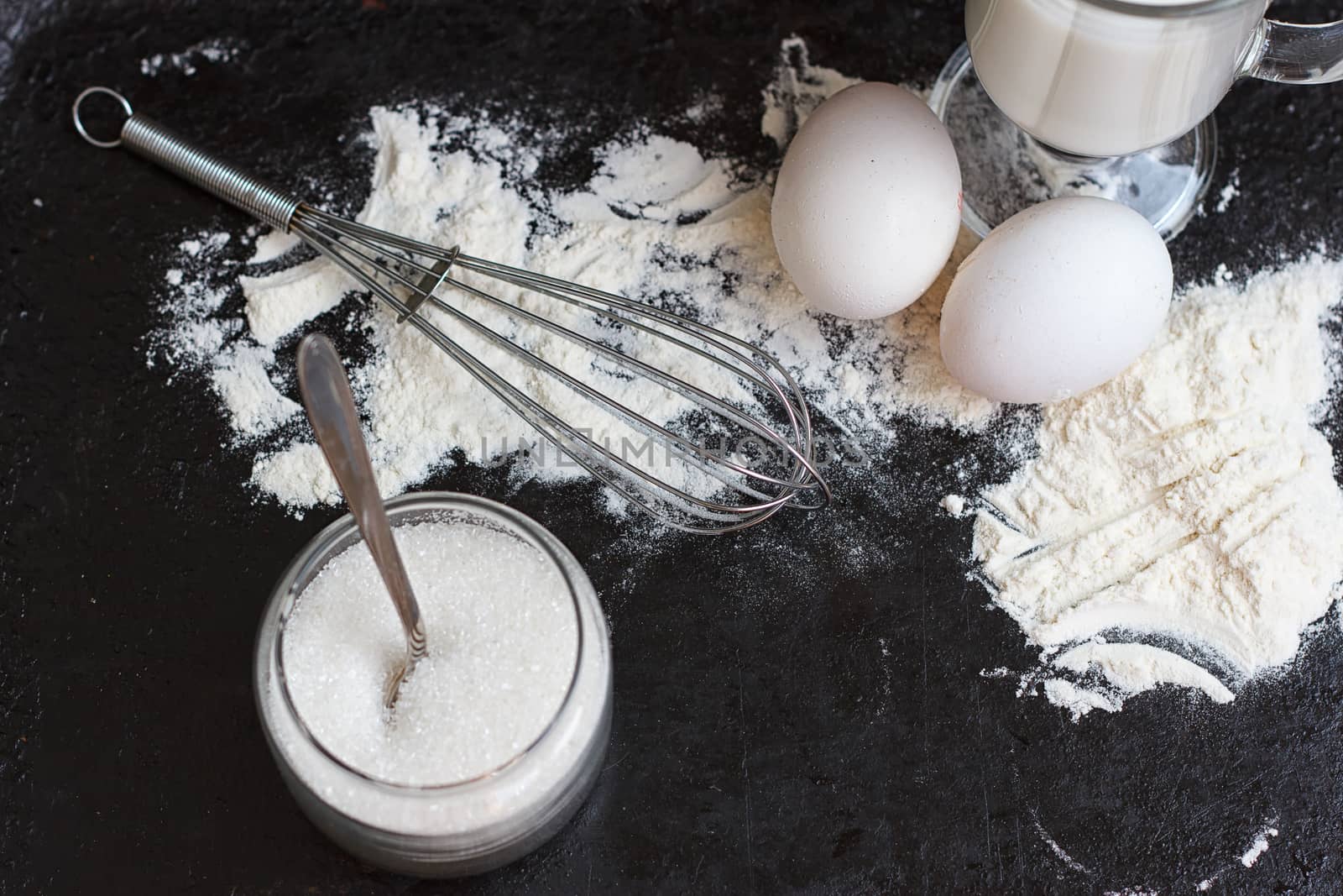 Ingredients for a cake on a black natural stone