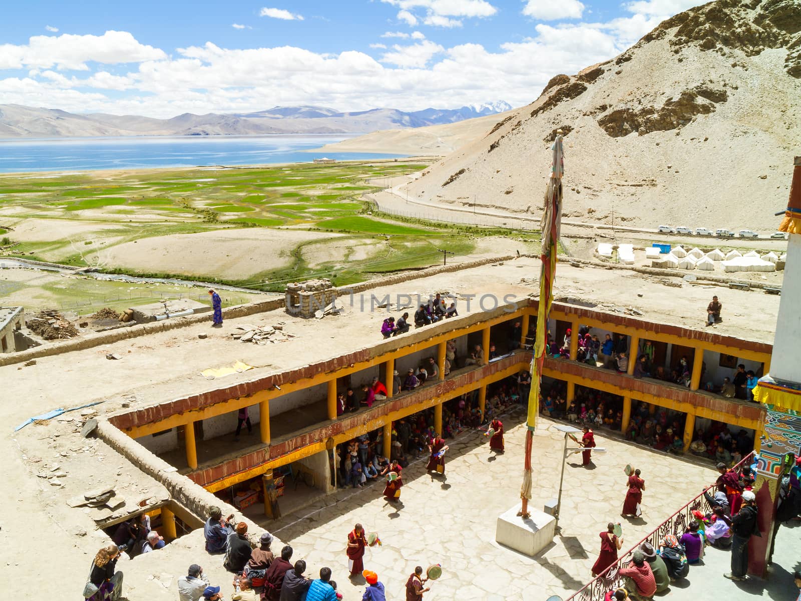 View from above on the Tso Moriri lake and courtyard of the monastery during the Cham Dance Festival of Tibetan buddhism, full of spectators and performers in Korzok monastery by straannick