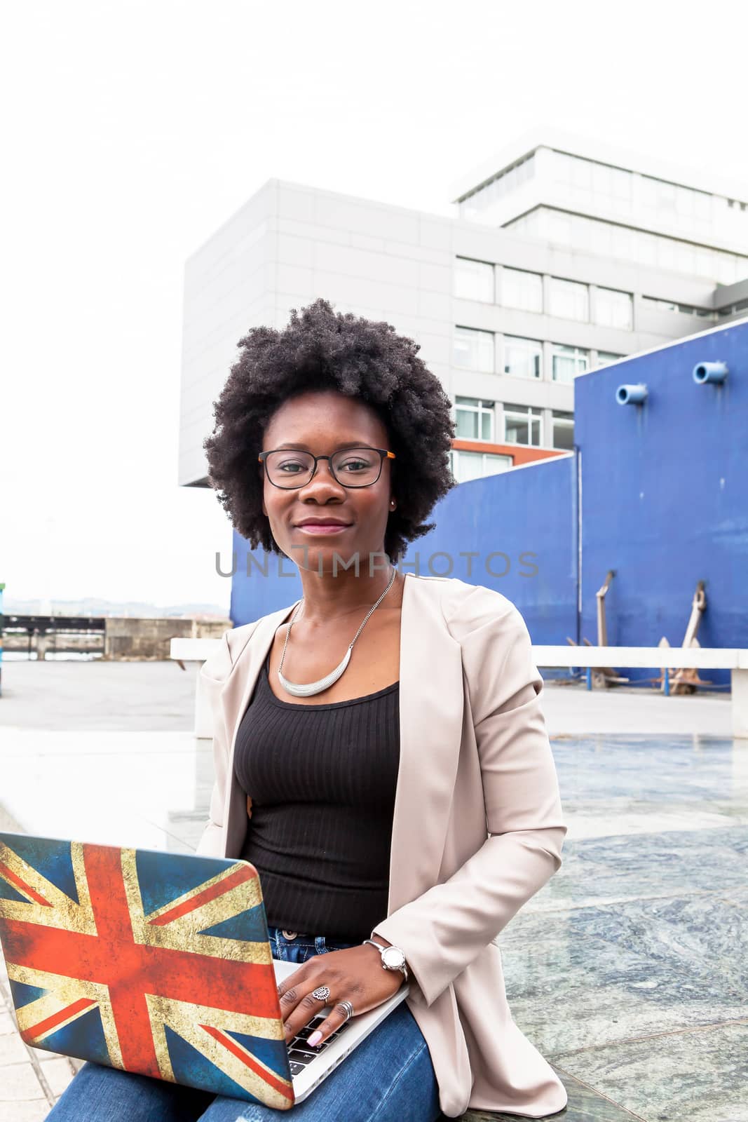 Modern African woman working outdoors with her laptop