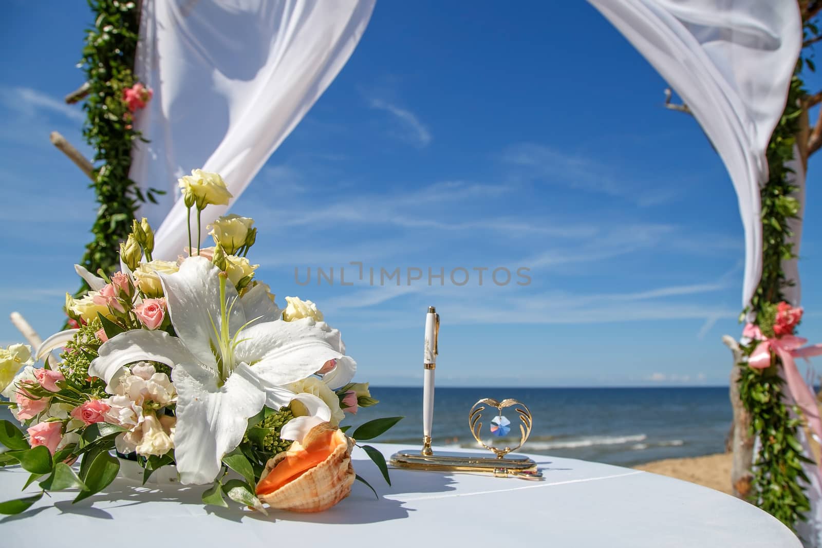 Wedding decoration of flowers and pen on the background of the sea