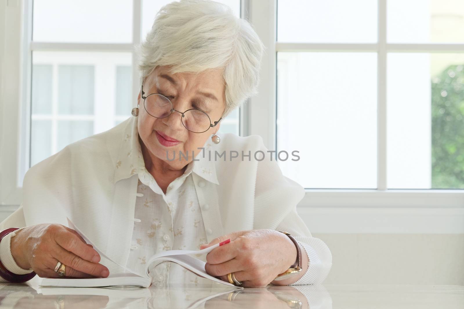 Senior woman reading a book at home