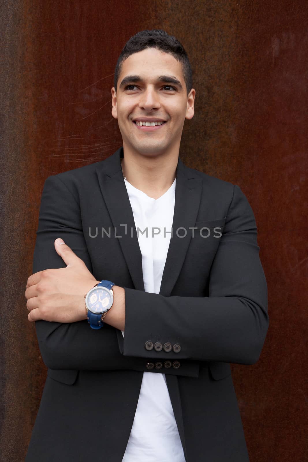 Portrait of a young man half french and half arabic happy with arms crossed