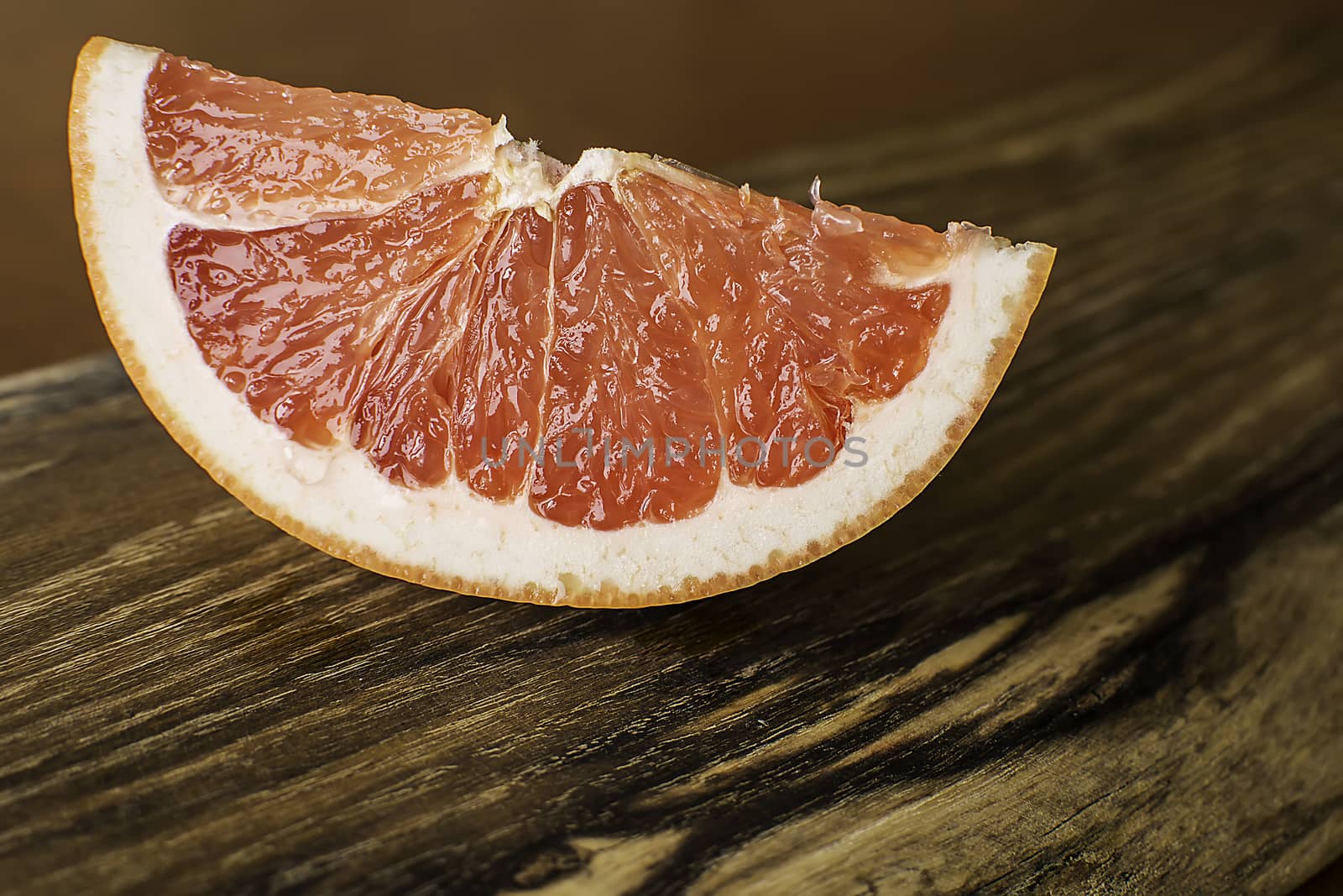 Slice of Red Juicy Grapefruit on Vintage Wooden Board by Victority