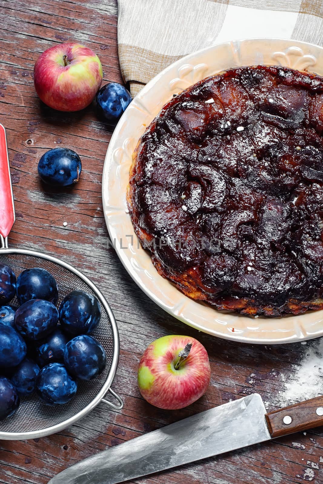 Apple pie with apples and plums in rustic style