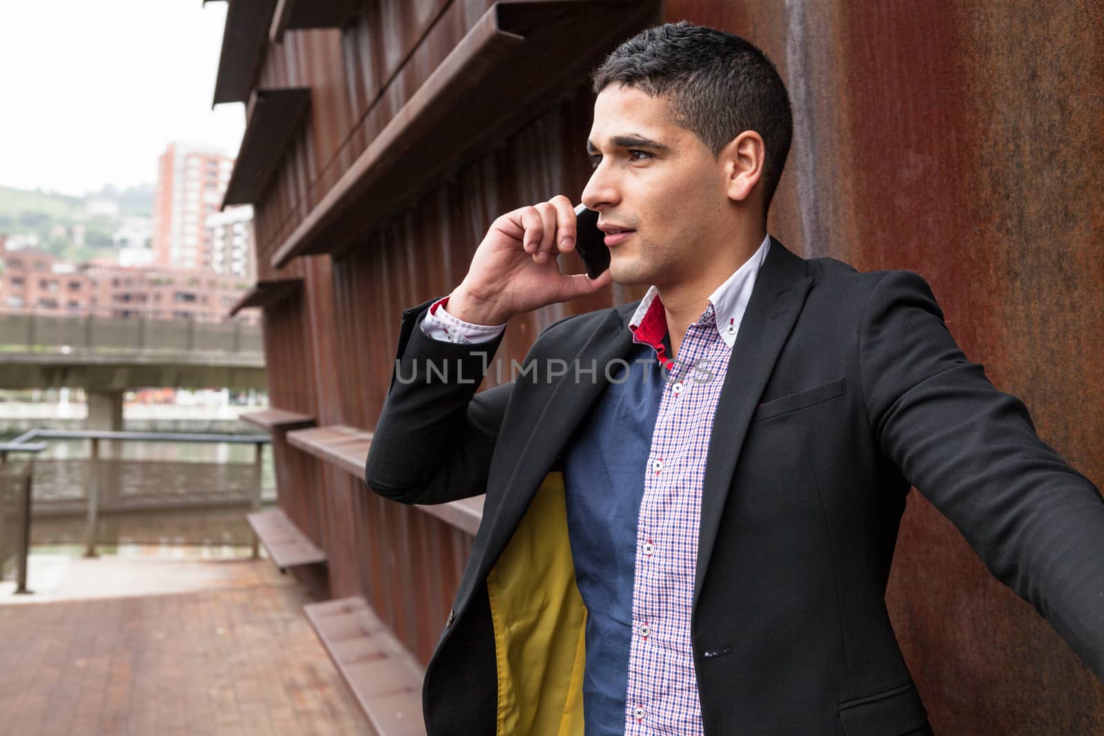 Portrait of a young man with talking on the phone by andongob