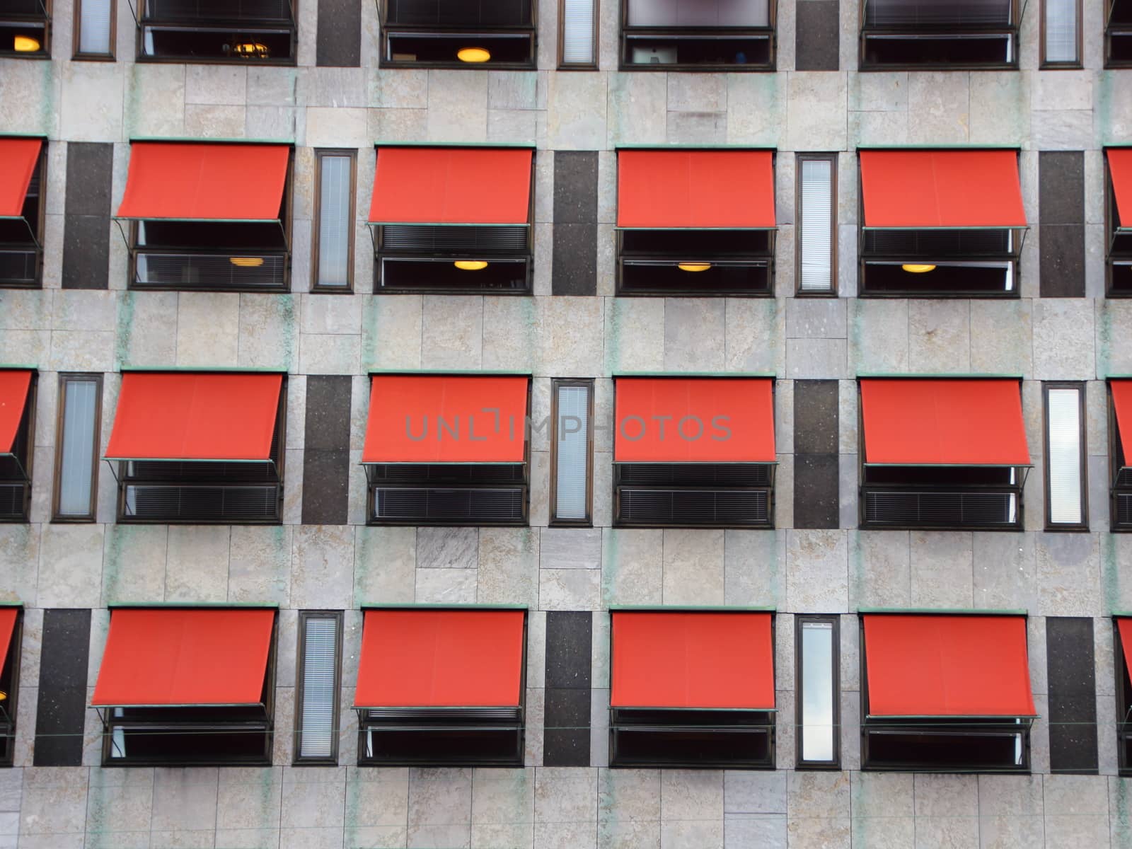 Twelve Red Overhang Sunshades on Modern Building Facade Protecting from the Sun
