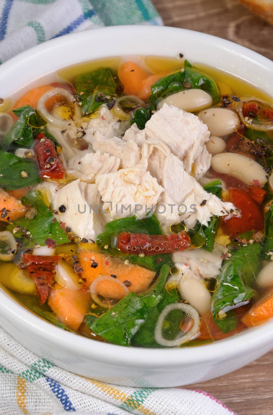 chicken soup with beans, spinach, tomatoes and other vegetables