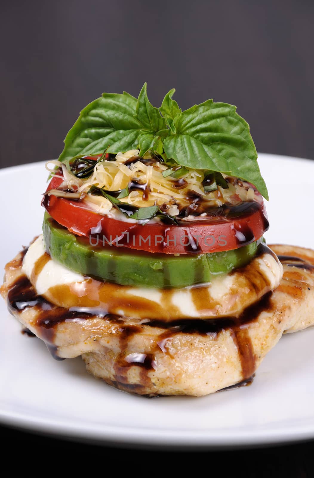 Chicken breast with slices of mozzarella, avocado, tomato and basil