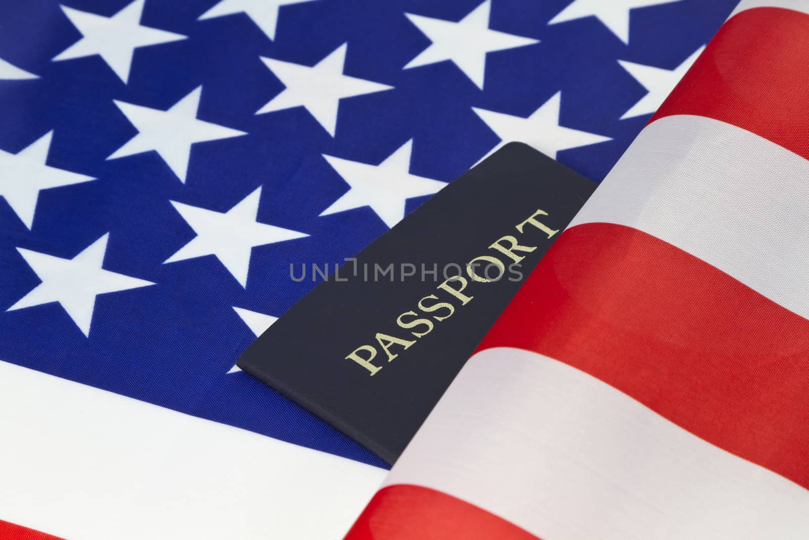 Stars and stripes of American flag are placed behind a passport reflecting pride in citizenship and travel. 