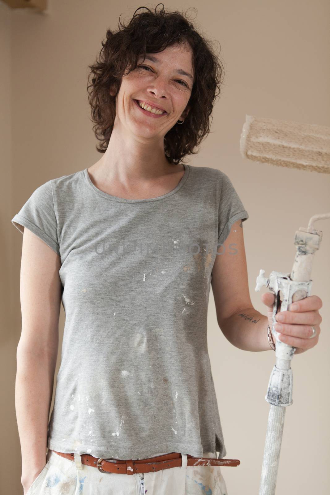 Professional working woman holding a paint brush roller at work