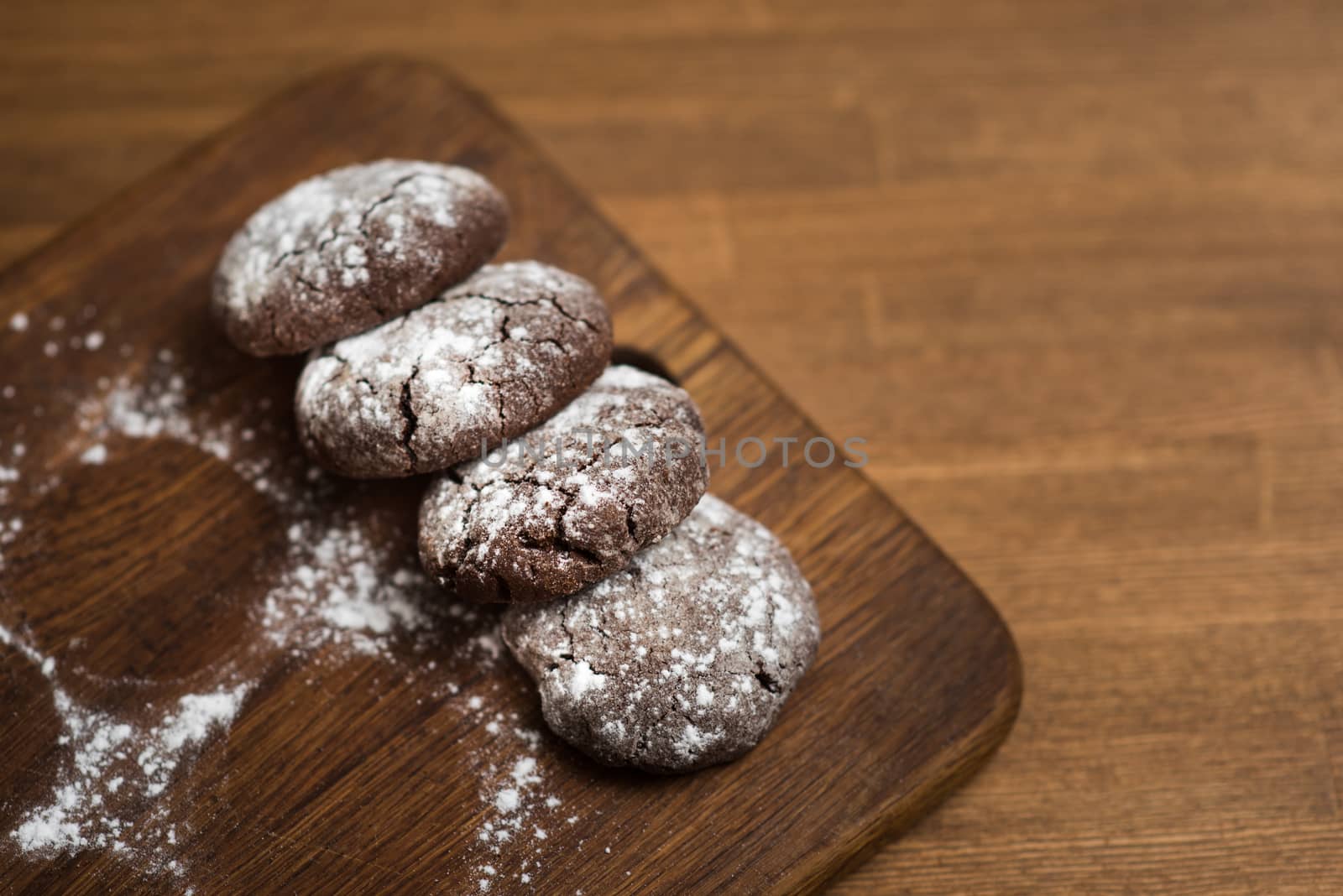 chocolate cookies with sugar powder on wooden kitchen Board