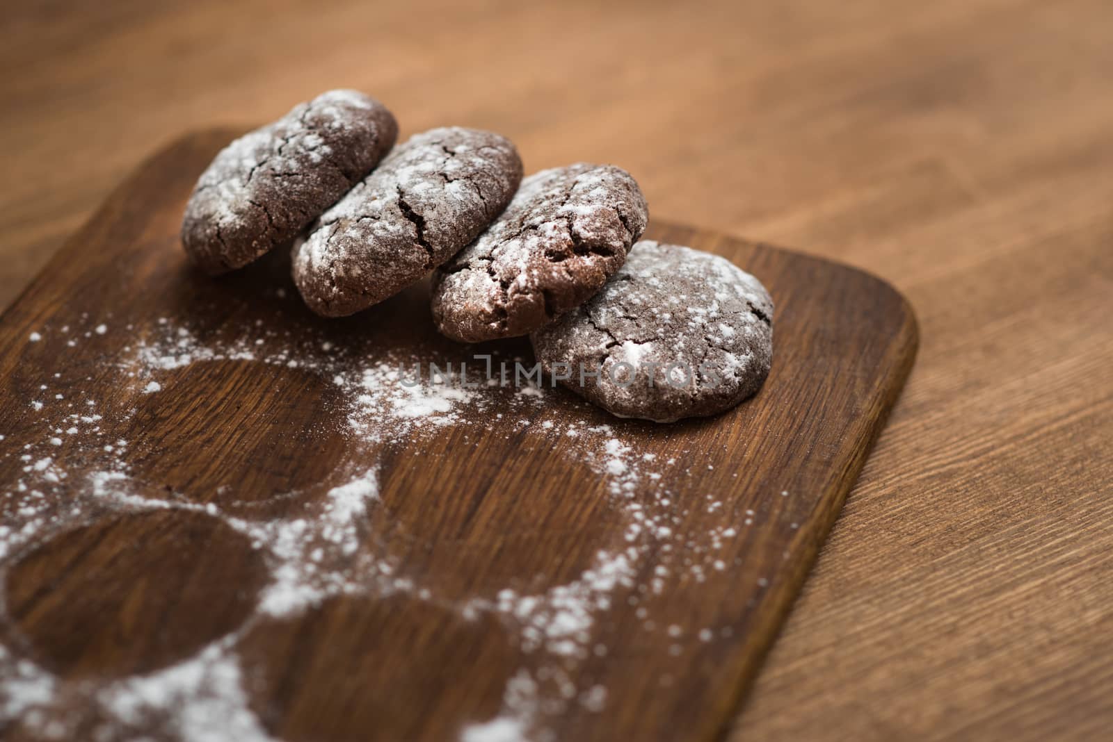 chocolate cookies with sugar powder on wooden kitchen Board