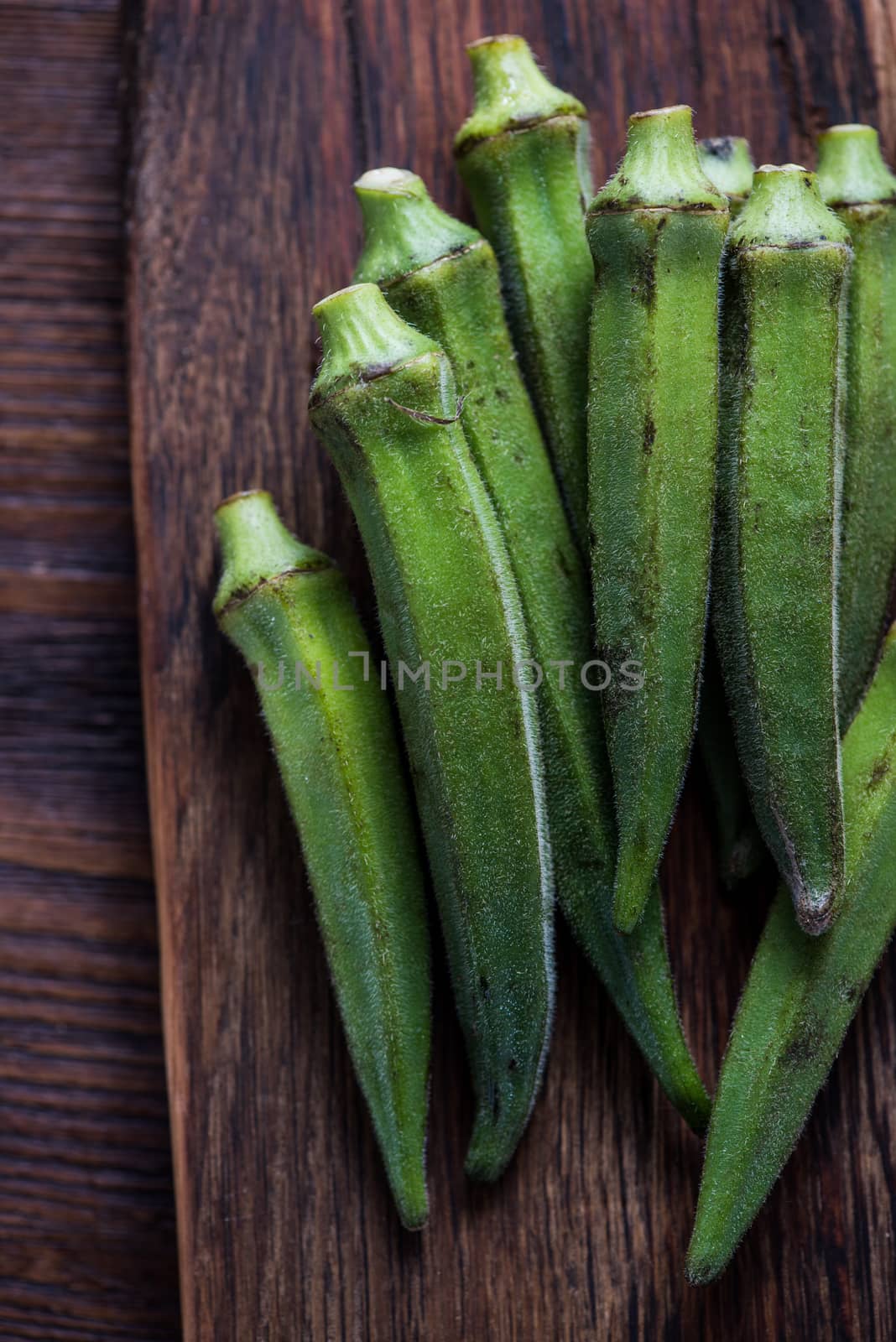 Fresh okra on wooden rustic cutting board